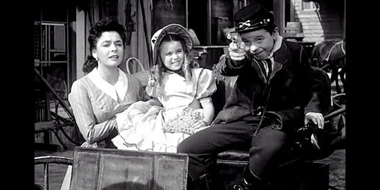 Bobby Clark as Peter Willoughby trying his new cap gun in front of his mother (Ruth Roman) and friend Lisbeth (Mimi Gibson) in Rebel in Town (1956)