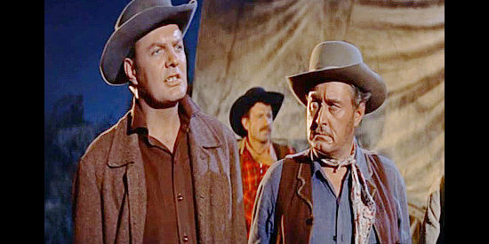 Charles H. Gray (left) as Tom Povis, suspicious of John Cord's motivations in Cattle Empire (1958)