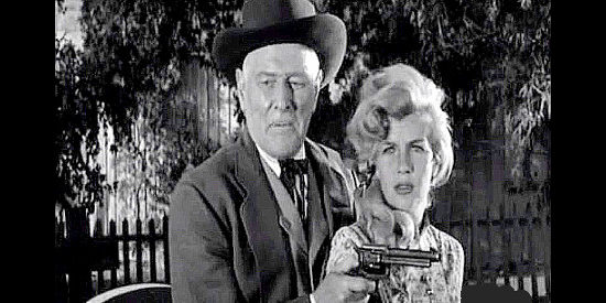 Corinne Calvet as Kathy Martin under the gun of Ed Sampson (George Macready) in Plunderers of Painted Flats (1959)