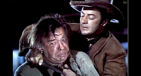 Cornel WIlde as Juan Obregon with a knife to the throat of Castro (Lon Chaney Jr.), demanding the names of those who attacked the Melo ranch in Passion (1954)