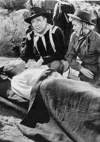 Dane Clark as Capt. Dave Stone and Dorothy Patrick as Murdock with wounded federal agent in Thunder Pass (1954)