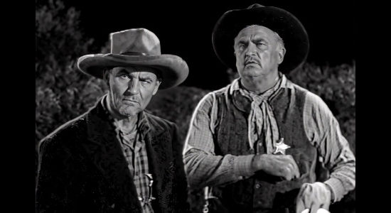 Emile Meyer as Shotgun Thompson and James Pierce as Bad Bill Pierce, astonished by the power of Queenie Hart's prayers in Cattle Queen (1951)