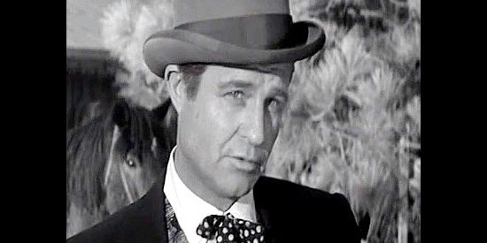 Jim Davis as Bill Cameron, a railroad detective trying to pass himself off as a snake oil salesman in The Last Stagecoach West (1957)