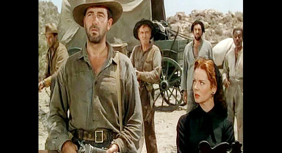 John Payne as Pete Black, showing up uninvited to the wagon train as Rose Billings (Arleen Whelan) looks on in Passage West (1951)