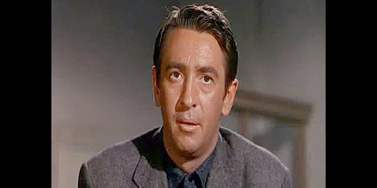 Macdonald Carey as Pete Carver, arriving in Copper Bend and realizing he has an almost limitless amout of credit in Cave of Outlaws (1951)