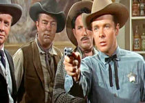 Audie Murphy as Tom Destry, showing he's quite adept at using a gun while Decker (Lyle Bettger) looks on in Destry (1954)