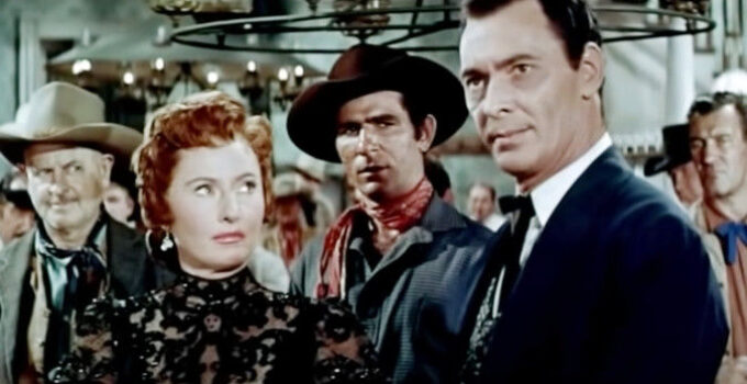 Barbara Stanwyck as Kit Banion, watching Jeff Younger (Barry Sullivan) settle a gambling dispute in her saloon in The Maverick Queen (1956)