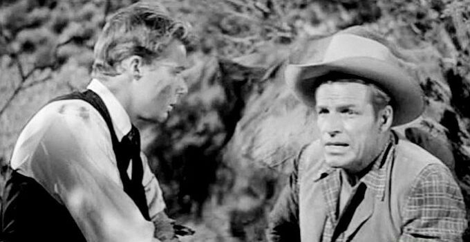 Buster Crabbe (right) as Linc Prescott, coming to the aid of a wounded Brother Van (John Smith) in The Lawless Eighties (1957)