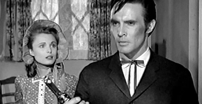 James Mitchell as Parson Butler, weighing a gun against his Bible as Ann Davis (Rosemarie Bowe) looks on in The Peacemaker (1956)