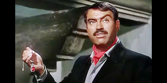 Pedro Armendariz as Gen. Eduardo Calleja, holding a key piece of evidence against the woman he loves in Border River (1954)