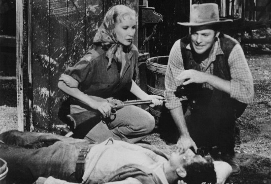 Penny Edwards as Susan Crowley and John Agar as Jeff Donner come upon a wounded Union agent in Ride a Violent Mile (1957)