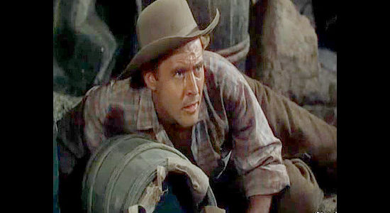 Peter Hansen as Michael Karns, the pastor's brother, watching a fight break out among the escapees in Passage West (1951)