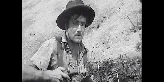 Peter Coe as Pierre Duchesne, one of Barstow's men, preparing to spring a trap on a Union patrol in Rocky Mountain (1950)