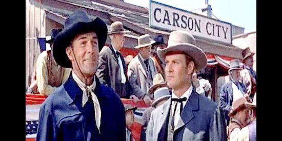 Randolph Scott as Jeff Kincaid celebrating the completion of the railroad as brother Alan (Richard Webb) looks on in Carson City (1952)