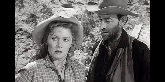 Rhonda Fleming as Candace Bronson under the watchful eye of a man named Perry (Douglas Spencer) in The Redhead and the Cowboy (1951)