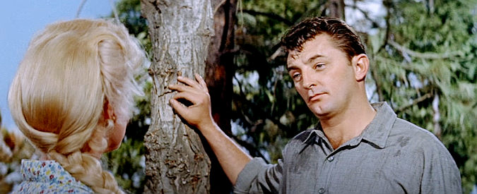 Robert Mitchum as Matt Calder, trying to figure out his lovely traveling companion in River of No Return (1954)