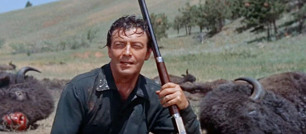 Robert Taylor as Charlie Gilson, resting among the carcasses of some of the buffalo he's killed in The Last Hunt (1956)