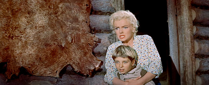 Tommy Rettig as Mark Calder and Marilyn Monroe as Kay watch an argument turn violent in River of No Return (1954)