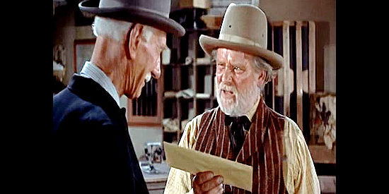 Wallace Ford as Postmaster Higgins, receiving a letter from a dead man to mail, courtesy of Pop Pruty (Clem Blevans) in The Boy from Oklahoma (1954)