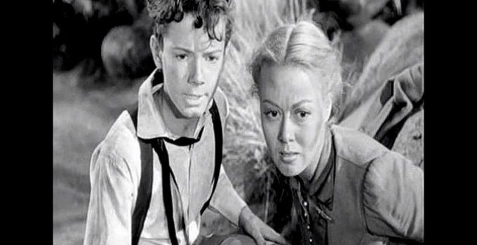 Peter Miles as Tommy Martin and Adele Mara as his sister Beth, fearing their lives are in danger as they're pursued up a mountain in California Passage (1950)