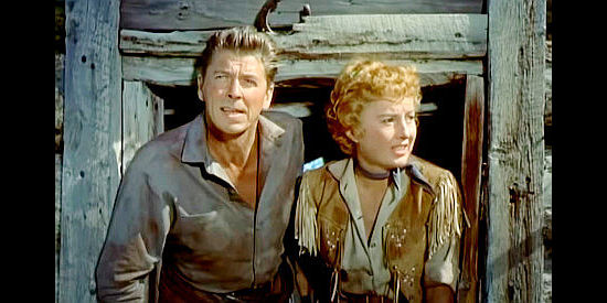 Ronald Reagan as Farrell and Barbara Stanwyck as Sierra Nevada Jones, on the watch for trouble in Cattle Queen of Montana (1954)