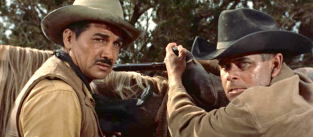 Victor Manuel Mendoza as Paco Mendoza and Glenn Ford as Tom Reese wondering how to deal with an ill-tempered partner in Cowboy (1958)