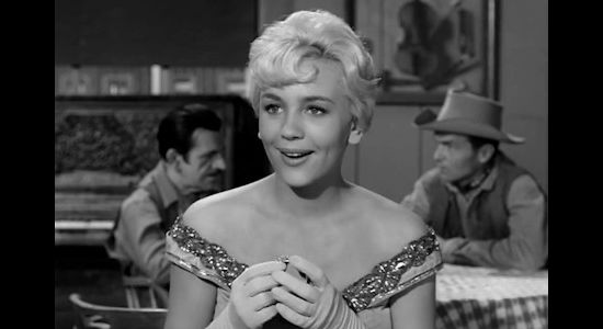 Joan Staley as Nora Blaine, reacting to a gift from Wayne Santley after her broach is stolen in Gun Fight (1961)