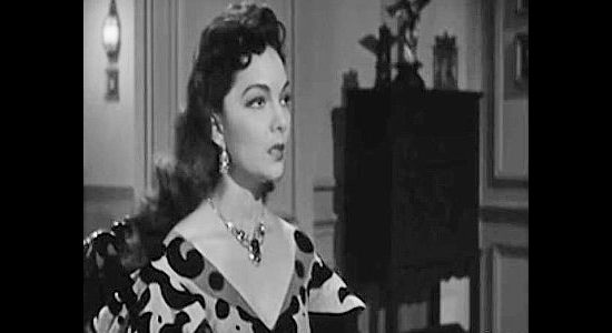 Lillian Molieri as Rita Aguilar, shocked by the news that the man she's romantically involved with might be an outlaw in The Three Outlaws (1956)