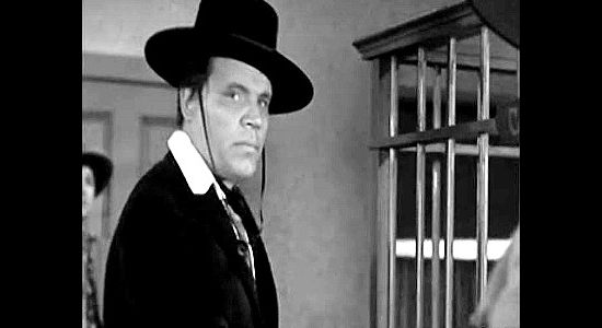 Neville Brand as Butch Cassidy, making a deposit, rather than a withdrawal, from a bank in The Three Outlaws (1956)