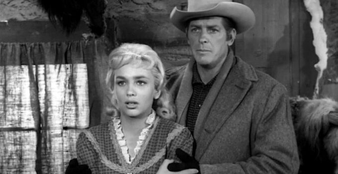 Joan Staley as Norah Blaine and James Brown as Wayne Santley, confronted by Brad's angry brother in Gun Fight (1961)