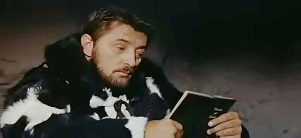 Robert Mitchum as Curt Bridges, reading some of his brother's poetry before using it to start a fire in Track of the Cat (1954)