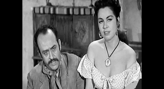 Rodolfo Hoyos as El Gallo and Jeanne Carmen as girlfriend Polimita, hearing about a bank ripe for robbing in The Three Outlaws (1956)