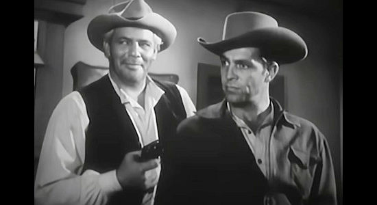 Buddy Baer as gang member Stan, with a gun in the back of Caleb Whales in Hell Canyon Outlaws (1957)