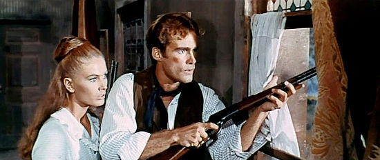 Ida Galli as Coralie and Sean Flynn as Timothy Benson, trying to fight off an attack by Rodriguez and his men in Seven Guns for Timothy (1966)