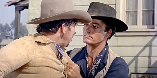 John Derek as Jet Cosgrave, returning home to find Boone Polsen spitting on a statue of his father in The Outcast (1954)