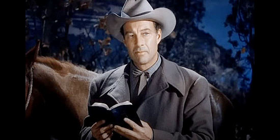 William Elliott as Zeb Smith, trying to convince Doll Brown she might find the answers to her problems in his Bible in Hellfire (1949)