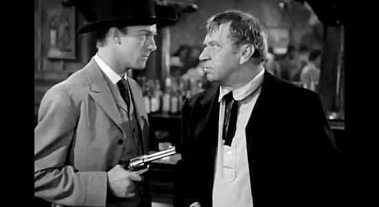 Dennis O'Keefe as Jeff Burton pulling a gun on Trigger Bill (Wallace Beery) in The Bad Man of Brimstone (1937)