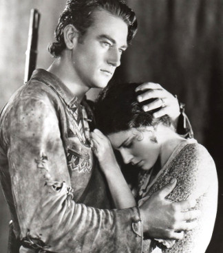 John Wayne as Breck Coleman with Marguerite Churchill as Ruth Cameron in The Big Trail (1930)
