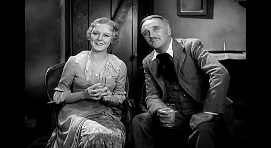 Kay Johnson as Claire Randall and Wyndham Standing as Jack Tunston, watching the cowboys celebrate in Billy the Kid (1930)
