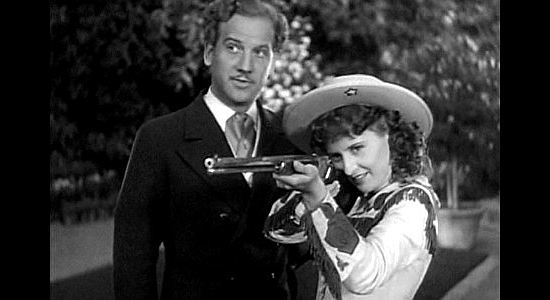 Melvyn Douglas as Jeff Hogarth watching Annie (Barbara Stanwyck) show off for European royalty in Annie Oakley (1935)