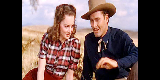 Olivia de Havilland as Abbie Irving and Errol Flynn as Wade Hatton, getting closer in Dodge City (1939)