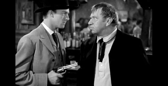 Dennis O'Keefe as Jeff Burton holding a gun on Trigger Bill (Wallace Beery) in The Bad Man of Brimstone (1937)
