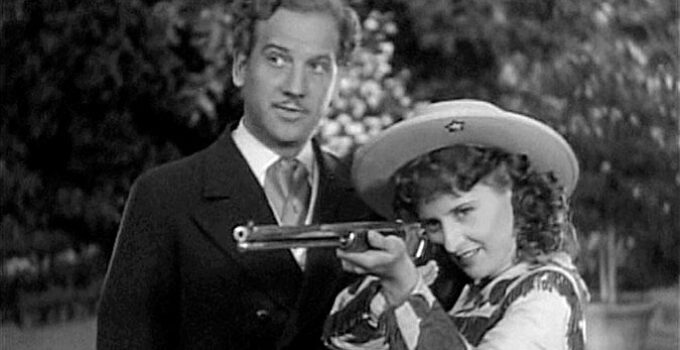 Melvyn Douglas as Jeff Hogarth watching Annie Oakley (Barbara Stanwyck) show off for European royalty in Annie Oakley (1935)