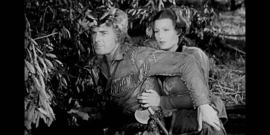 Randolph Scott as Hawkeye and Binnie Barnes as Alice Munro, watching for pursuing Hurons in Last of the Mohicans (1936)