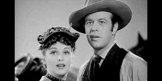 Rosemary Lane as Jane Hardwick and Harvey Stephens as Ned Kincaid, reacting to an alert that the land rush is about to begin in The Oklahoma Kid (1939)