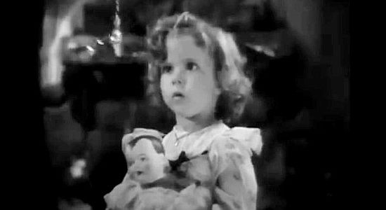 Shirley Temple as Mary Stanley, mexmerized by a pocket watch while holding her new doll in To the Last Man (1933)