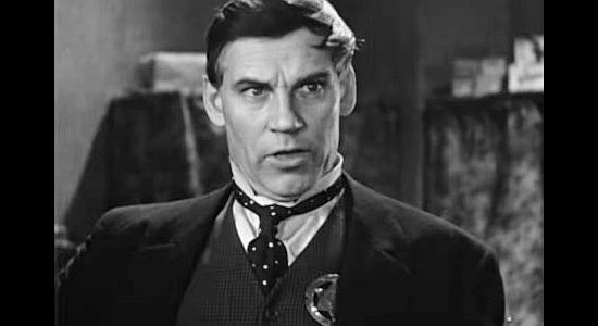 Walter Huston as Frame Johnson, pinning on a badge one more time in Tombstone in Law and Order (1932)