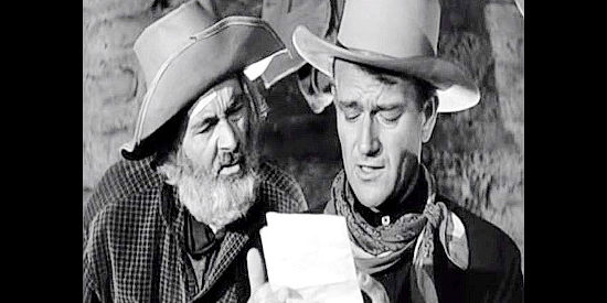 Gabby Hayes as Dave and John Wayne as Rocklin, reading a letter from Clara Cardell in Tall in the Saddle (1944)