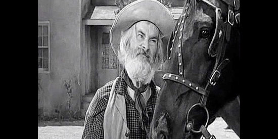 Gabby Hayes as Dave, upset with a horse named Blossom for breaking a bottle of whiskey in Tall in the Saddle (1944)