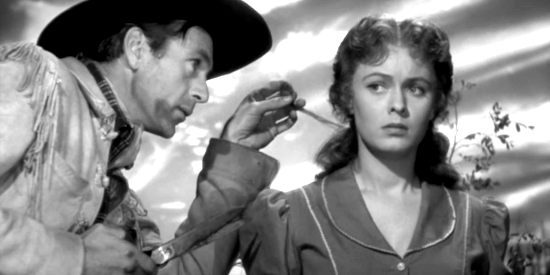 Gary Cooper as Cole Harden snipping a lock of hair from Jane Mathews (Doris Davenport) in The Westerner (1940)